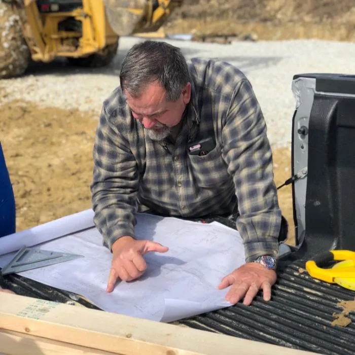Gerald Mixon looking over blueprints for concrete project.