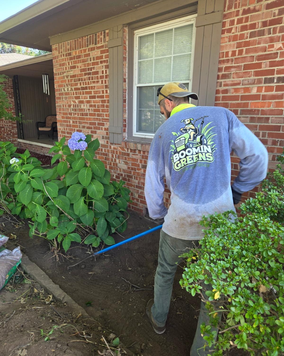 worker leveling out garden bed before laying mulch