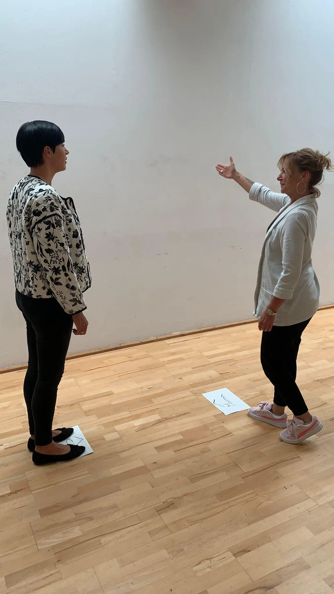 A holistic consultant analyzing a hair mineral analysis chart on a digital tablet, with a healthy professional client beside her, both smiling in a bright, plant-filled consultation room. 3:2 aspect ratio.