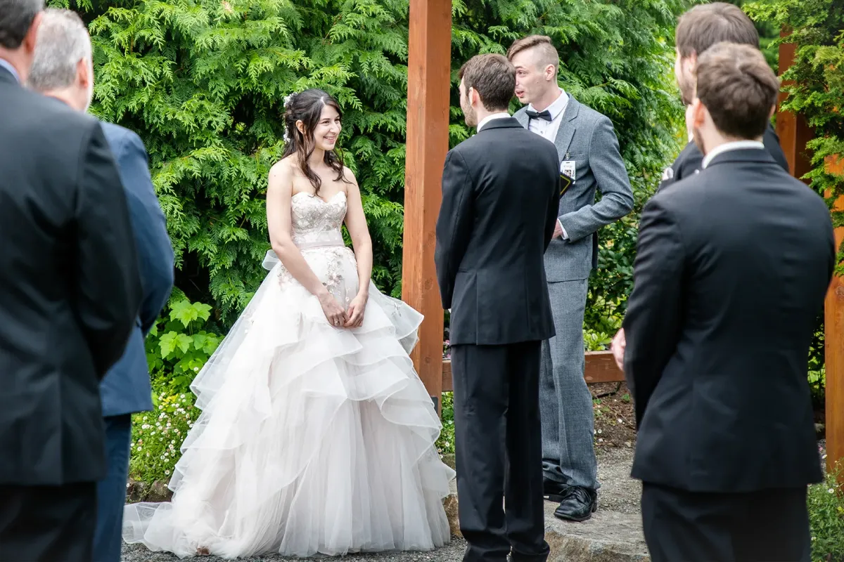 Couple stands under arch at Willows Lodge for their wedding ceremony