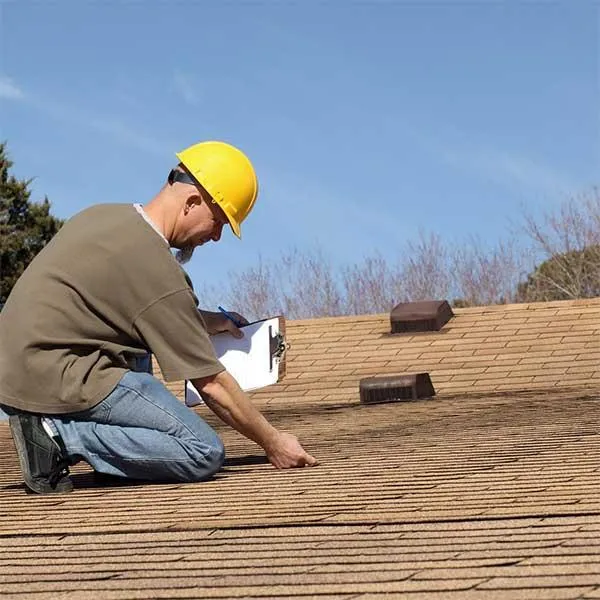 a Tucson roofer inspecting an asphalt shingle roof