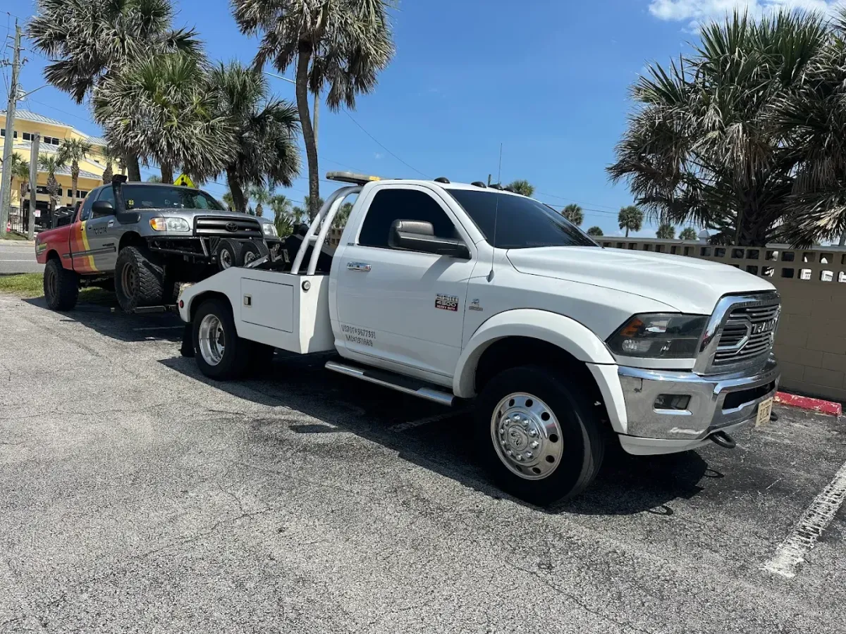Unlimited Towing & Transport white tow truck carrying a vehicle in Kissimmee FL