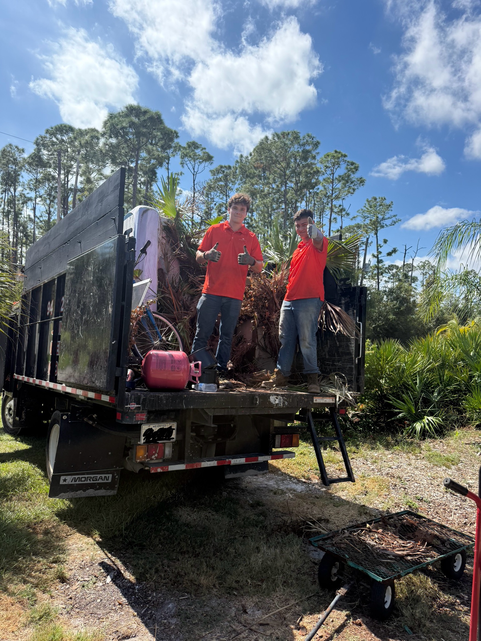 Suncoast Haul & Junk crew loading junk into truck in Sarasota driveway