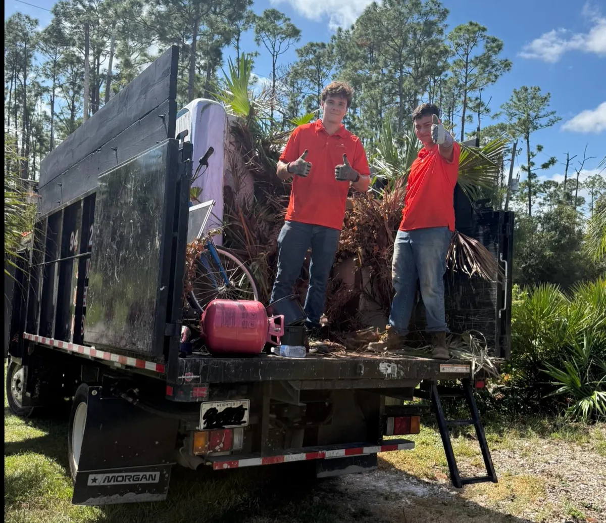 Suncoast Haul & Junk crew loading junk into truck in Sarasota driveway