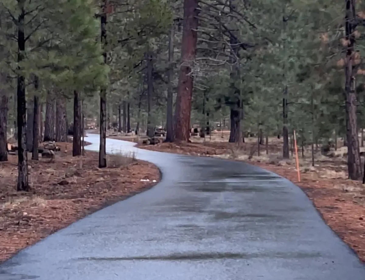 A person placing a piece of wood into a pyramid