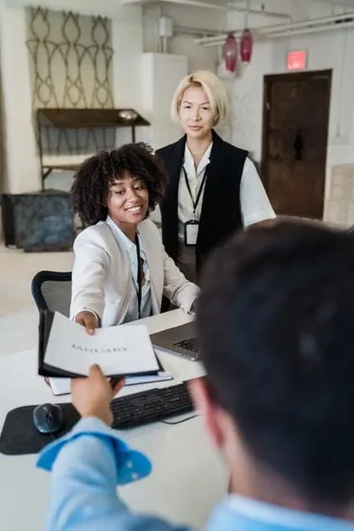 Business coach presenting growth strategies and key performance metrics on a whiteboard during a professional coaching session.