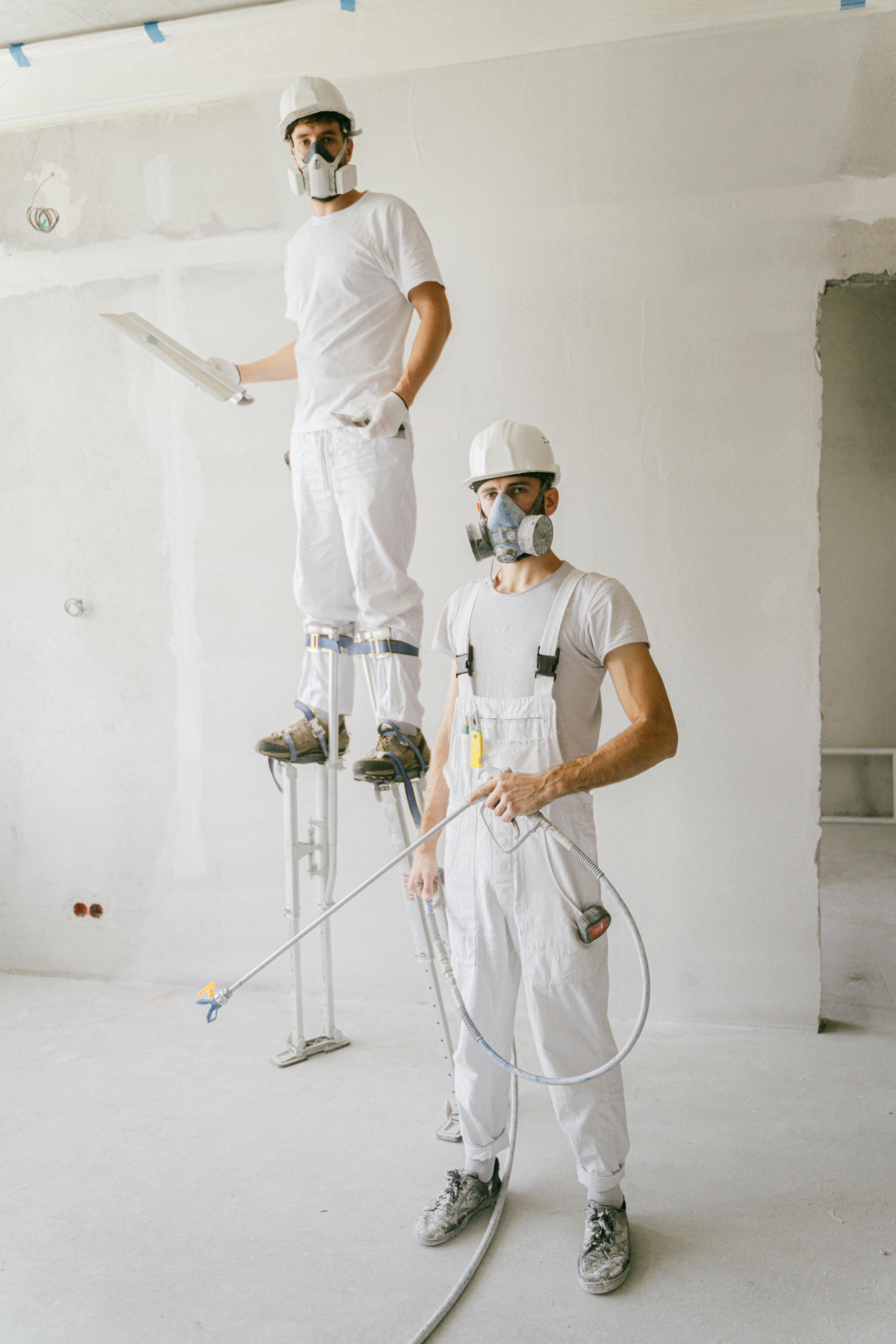 two white shirt men using paint sprays