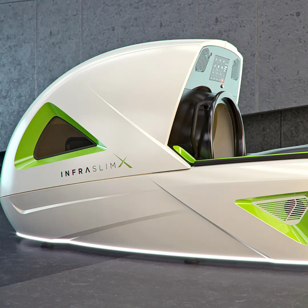 InfraslimX machine in a white and green color scheme with illuminated edges. The top part of the machine is open, revealing the interior with a screen and seating area. The ‘INFRASLIMX’ logo is visible on the side.