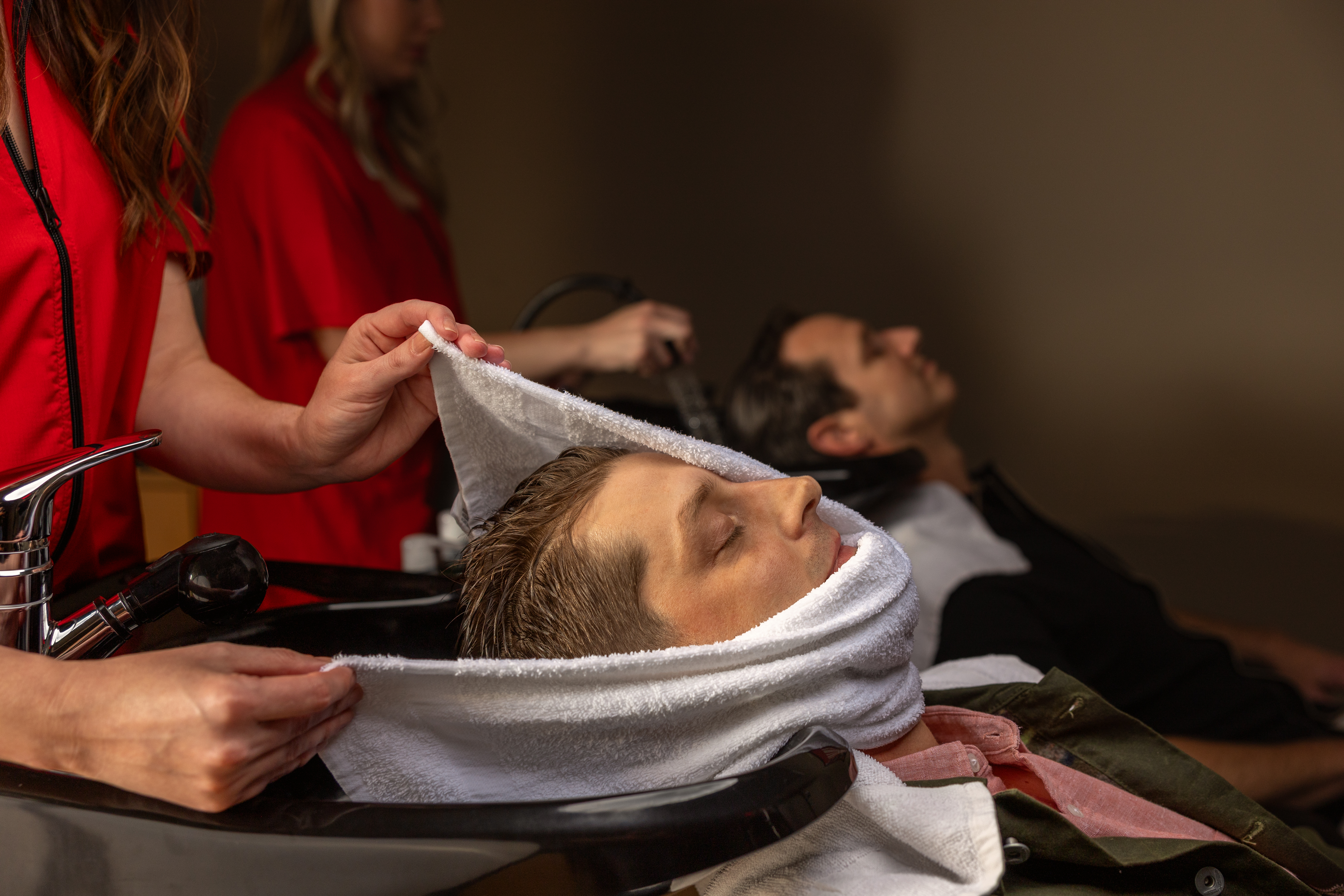 Man stretching legs on outdoor exercise equipment.