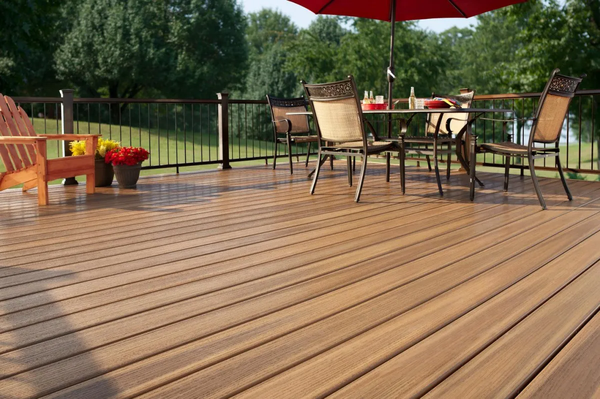 Spacious wooden deck with outdoor dining set and lush garden view for serene outdoor living.