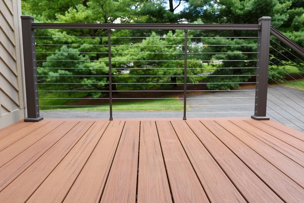 Modern residential outdoor deck featuring brown synthetic planks and a sleek, dark railing system, blending functionality with contemporary design.