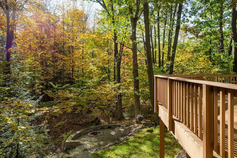 Outdoor backyard with fall foliage and light brown deck.