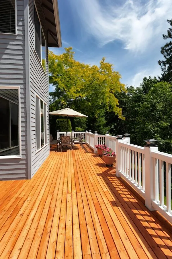 Spacious wooden deck installation by Skyline Decks surrounded by vibrant autumn foliage.