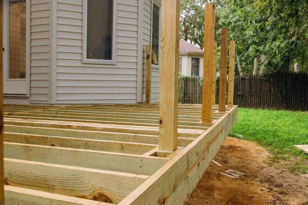 Early-stage construction of a wooden deck at a residential property, showcasing framework and quality materials.