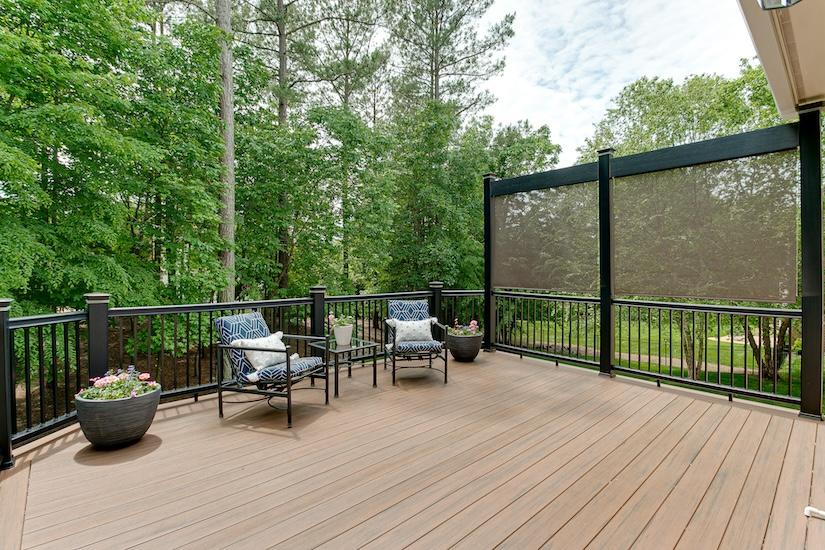 Relaxing deck area with comfortable seating and lush forest backdrop, perfect for enjoying nature and tranquility at home.