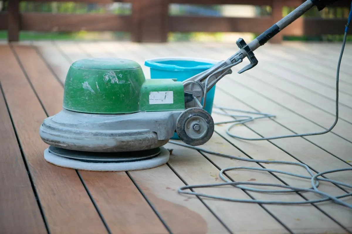 Professional deck maintenance service using power sander on wooden deck for Skyline Decks company.