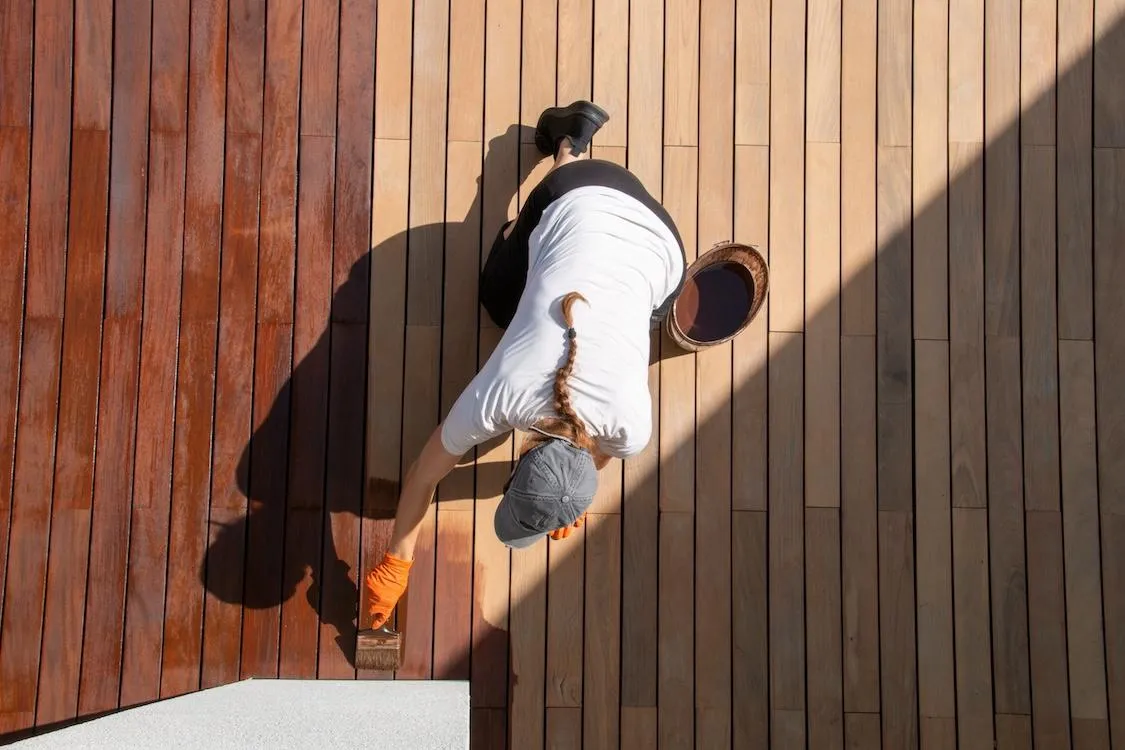 Expert deck staining by Skyline Decks professional applying a fresh coat on a wooden deck surface.