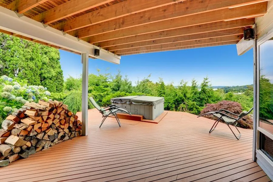 Spacious outdoor deck with hot tub and relaxing chairs overlooking a scenic view, highlighting Skyline Decks' expertise in creating luxury outdoor living spaces.