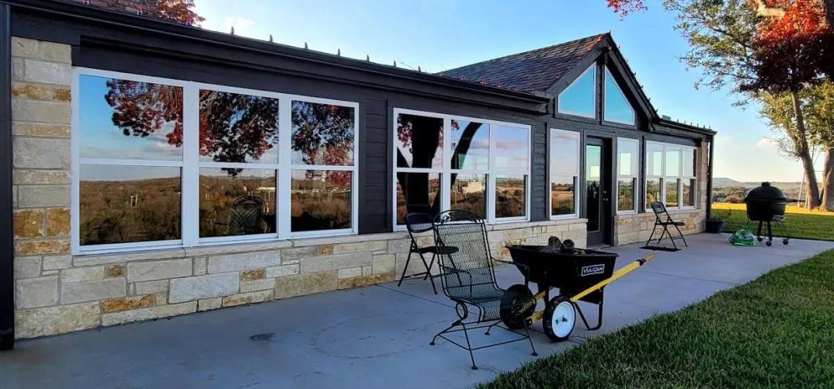 Option 1: "Professional window cleaning by Shinetime Solutions on modern stone building with large glass panels and outdoor seating area