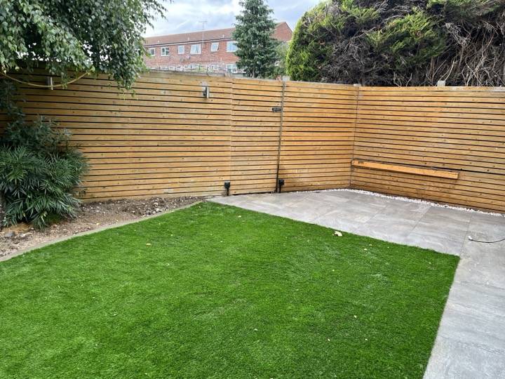 Artificial grass with patio and slatted fence — garden landscaping in Reading, Berkshire