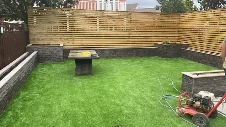 Artificial grass installation with raised planters and horizontal slatted fence — Reading, Berkshire