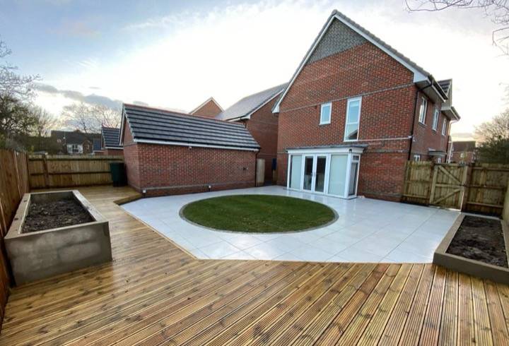 Timber decking with white patio and circular turf lawn — garden project in Reading, Berkshire