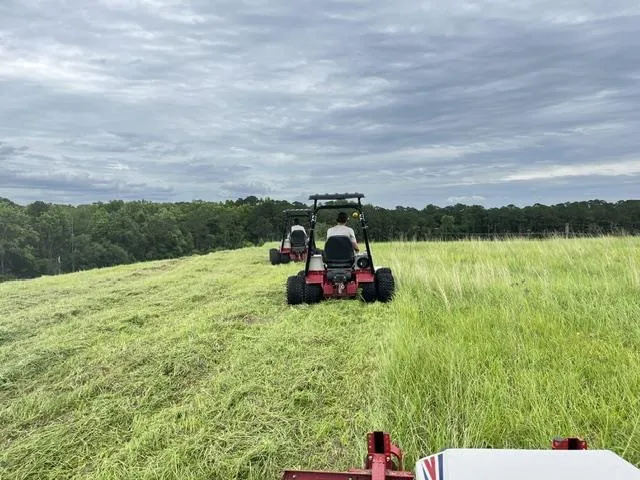 Tractor mowing stormwater pond bank South Carolina