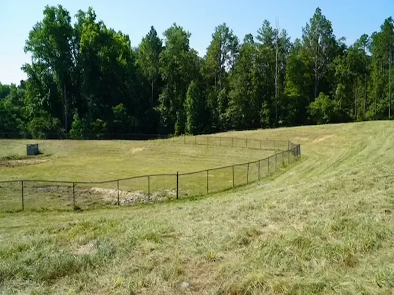 Mowed retention pond with fencing commercial property