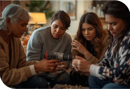 Picture of four woman. One with a drill in her hand and they are all leaning how to use the drill.