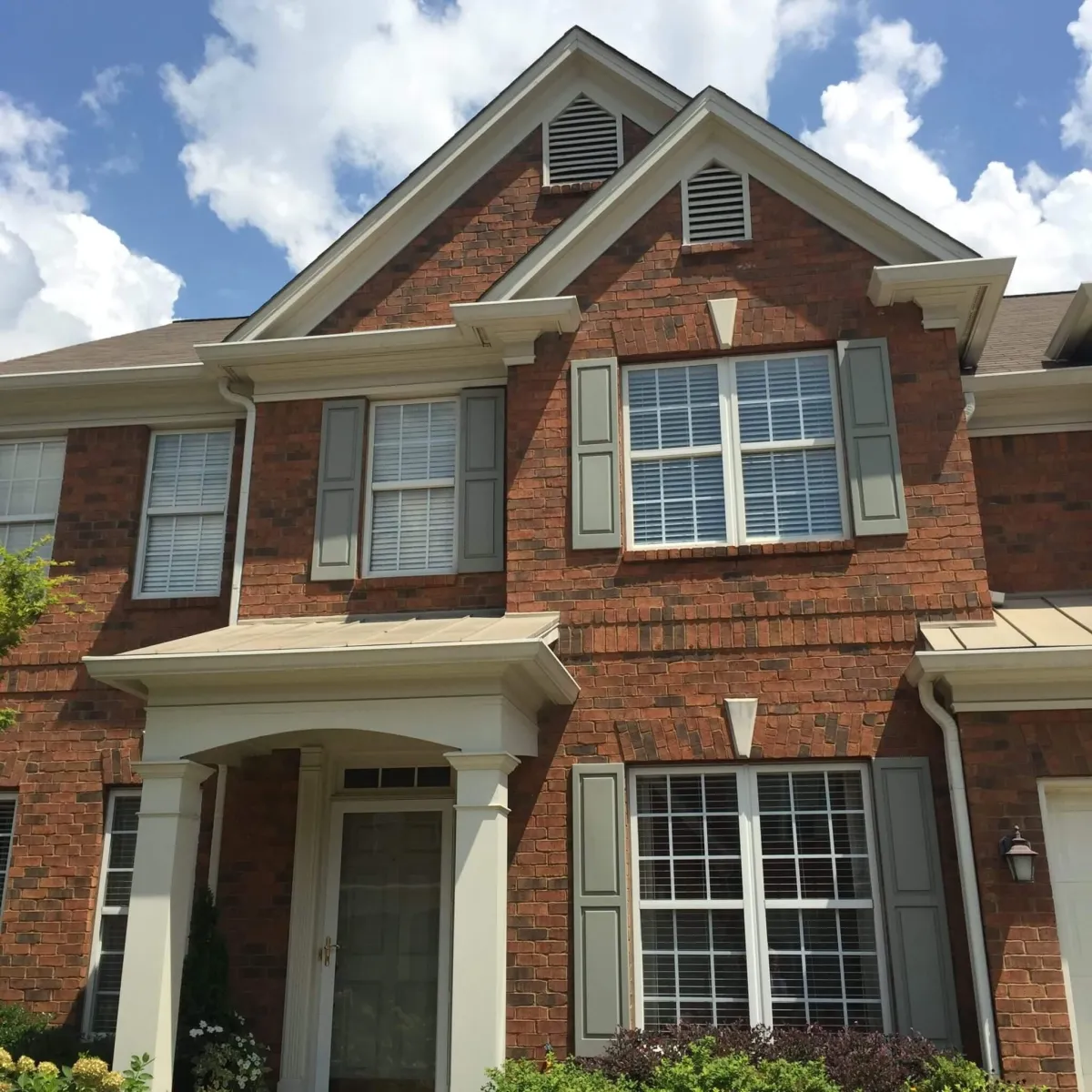 A beautiful brick home in North Atlanta showcasing a classic, mottled limewash finish with a timeless, rustic patina.