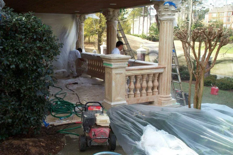 Earthly Matters painter pressure washing a brick house in Milton, GA, in preparation for a professional brick painting service.