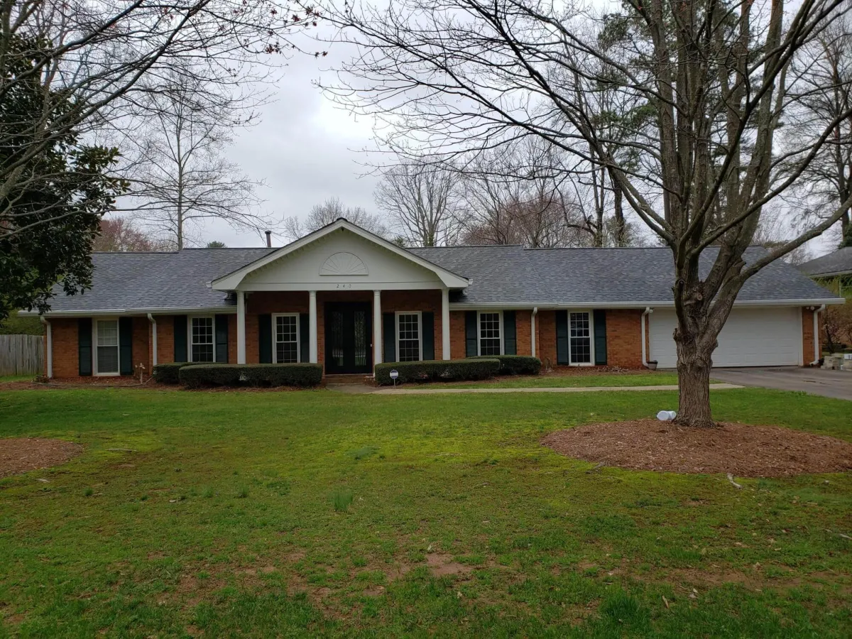 raditional red brick ranch home with brown shutters and trim before receiving a modern color palette