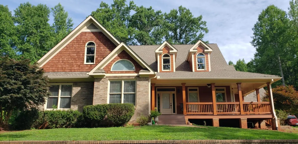 Vibrant craftsman home with freshly painted siding and beautifully re-stained wood shake and porch details.