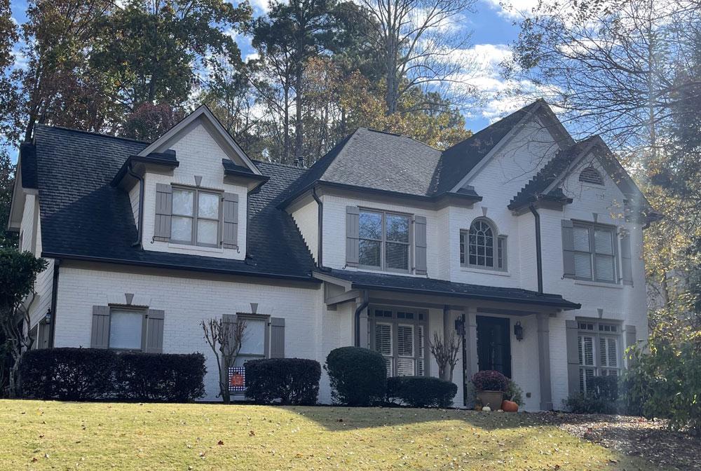 A breathtaking view of the same home, now with a bright and modern white limewash finish that enhances its architectural details.