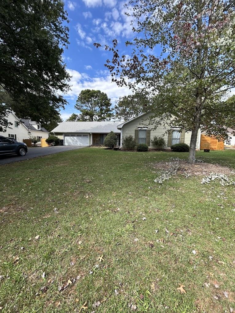 Dated ranch-style home with tan siding and an unkempt front yard before its exterior transformation.