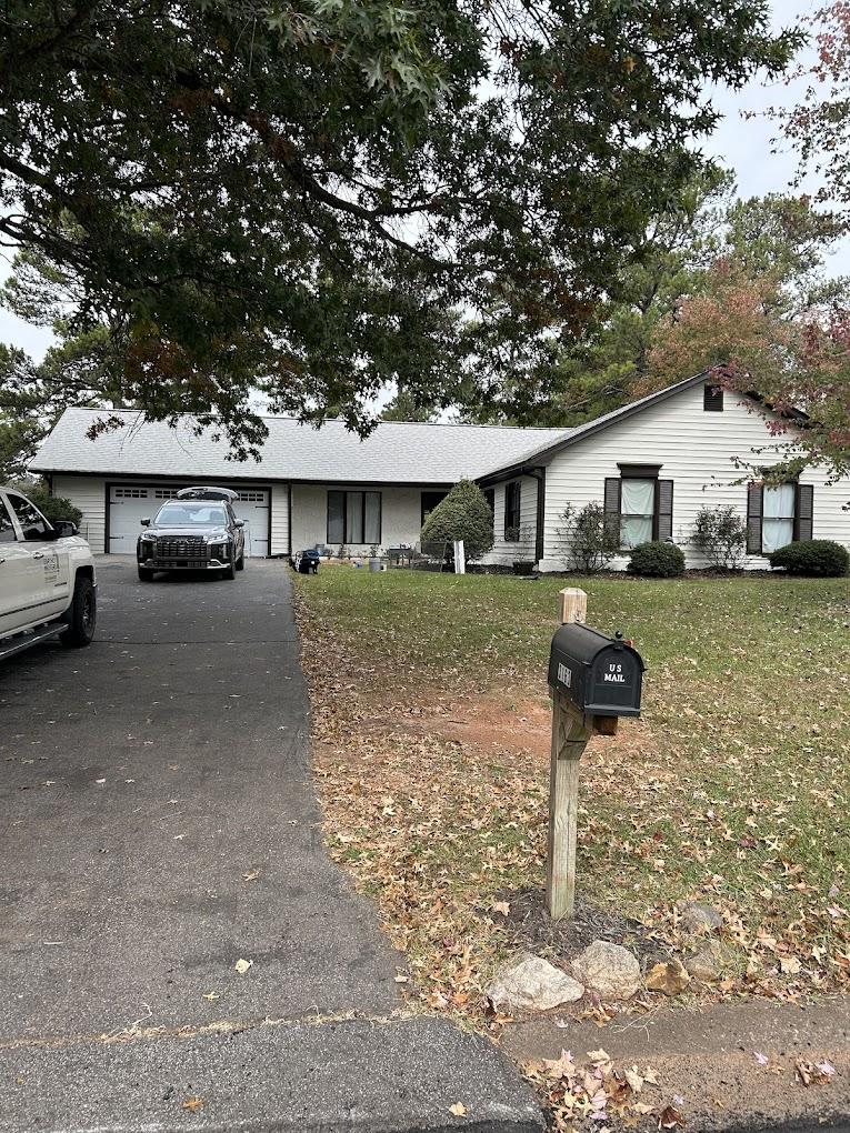 Modernized ranch home after being painted a clean white with contrasting black shutters and a tidy driveway