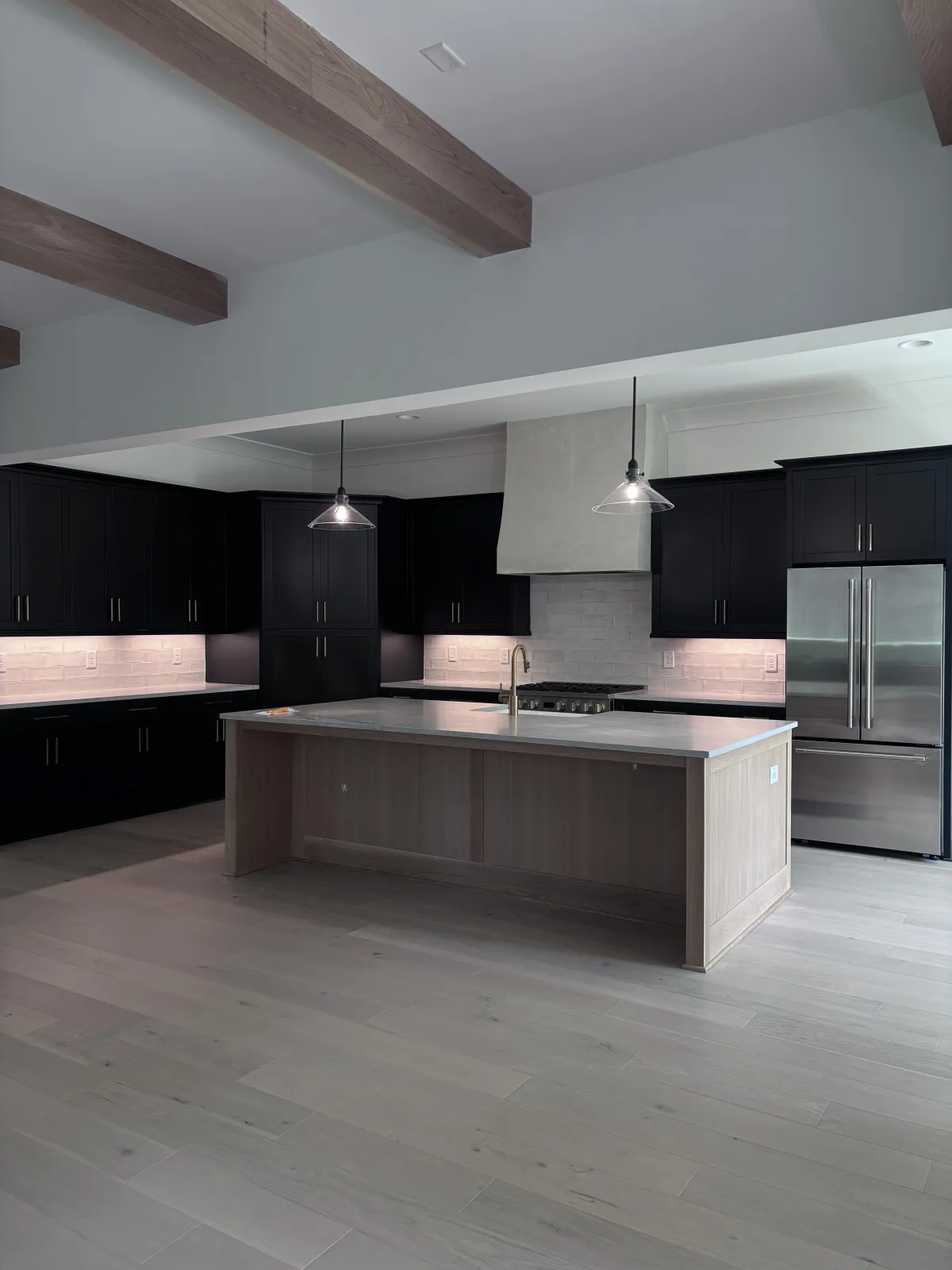 A beautifully transformed kitchen with freshly painted black cabinets after reassembly and final inspection by the Earthly Matters team.