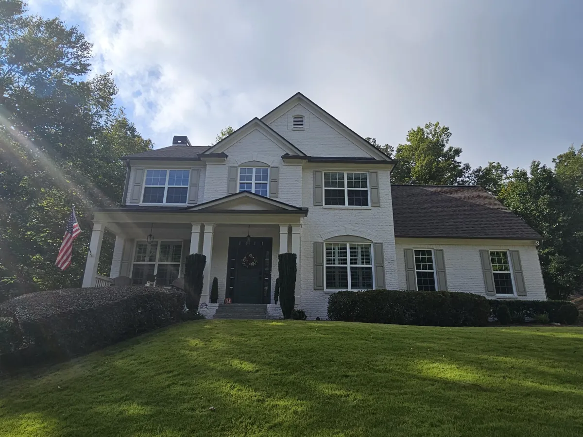A lovely two-story home with light-colored siding before receiving a professional exterior paint refresh.