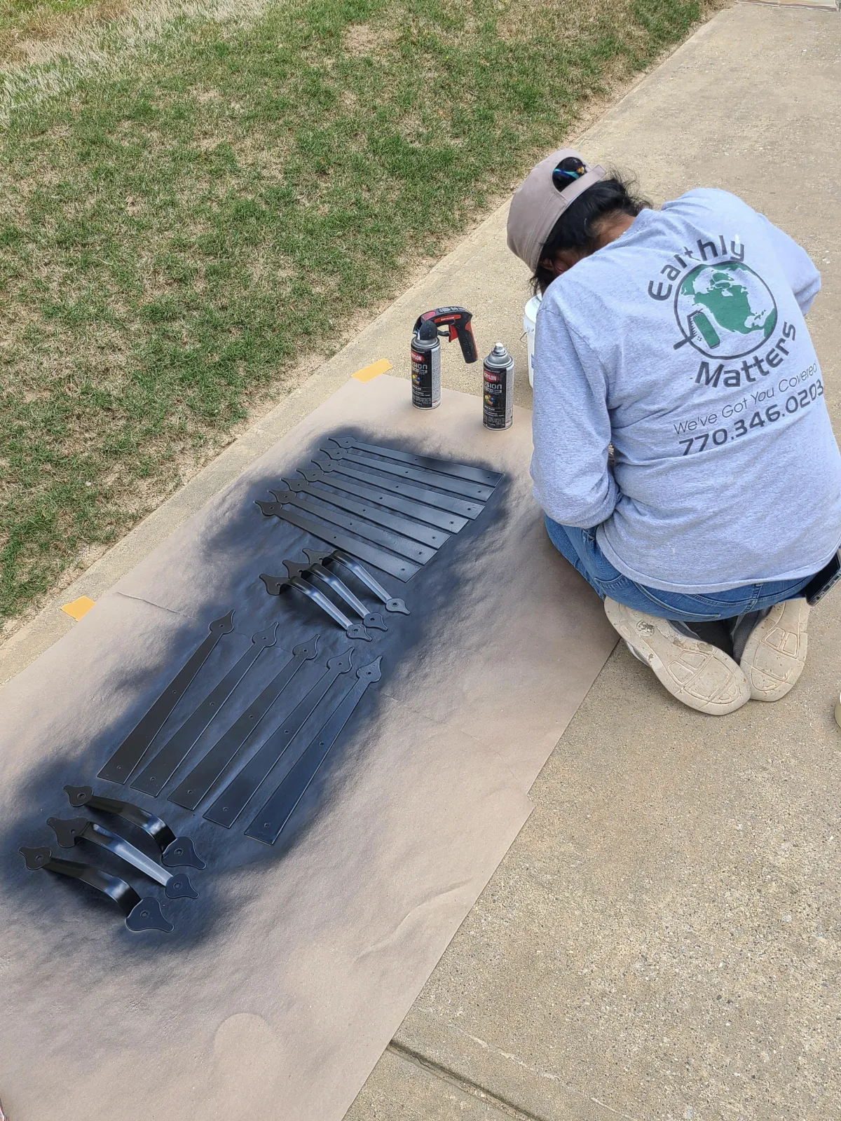 Earthly Matters technician carefully removing and painting cabinet hardware for a North Atlanta kitchen before reinstalling for professional painting.