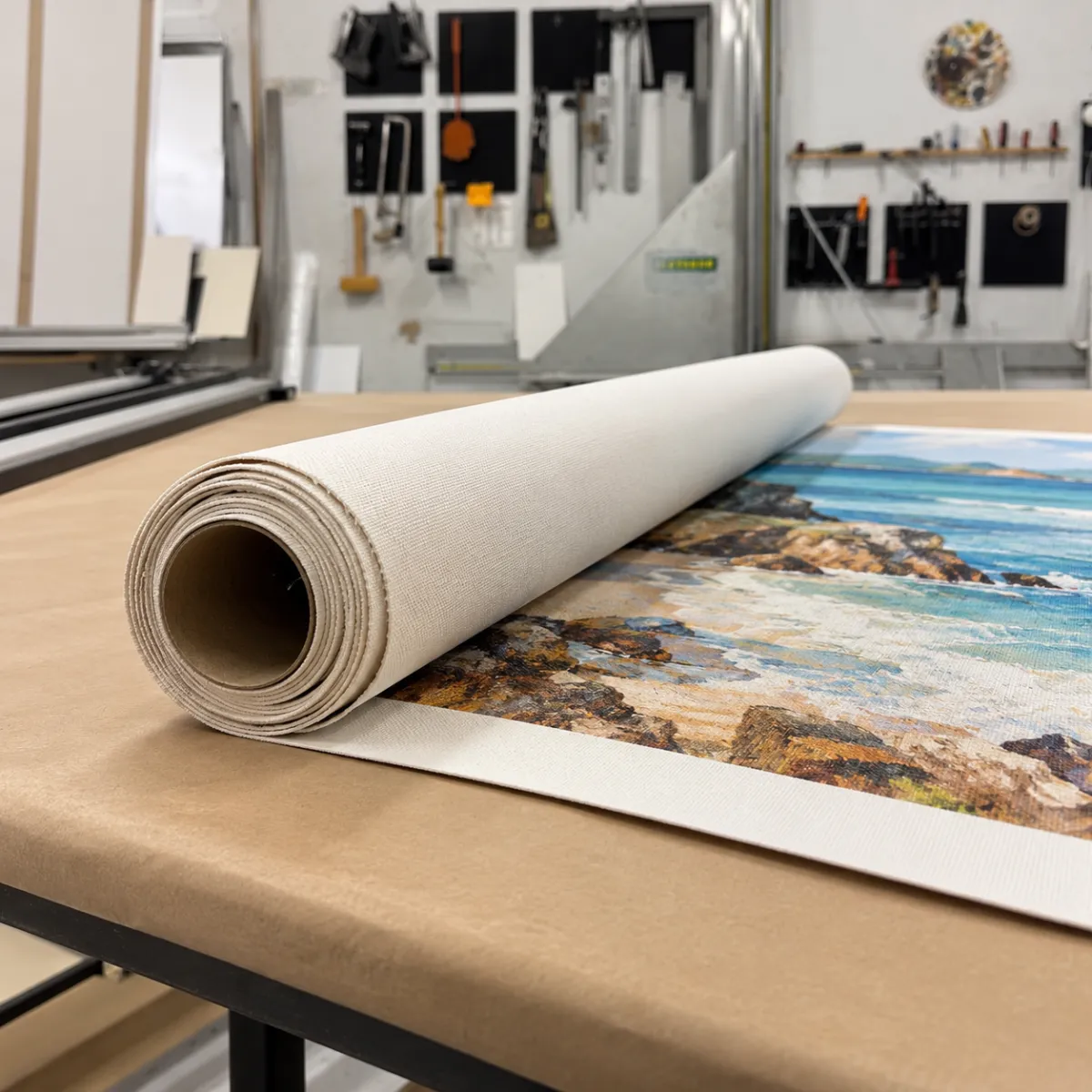 Rolled canvas artwork on a worktable in a professional Los Angeles picture framing studio