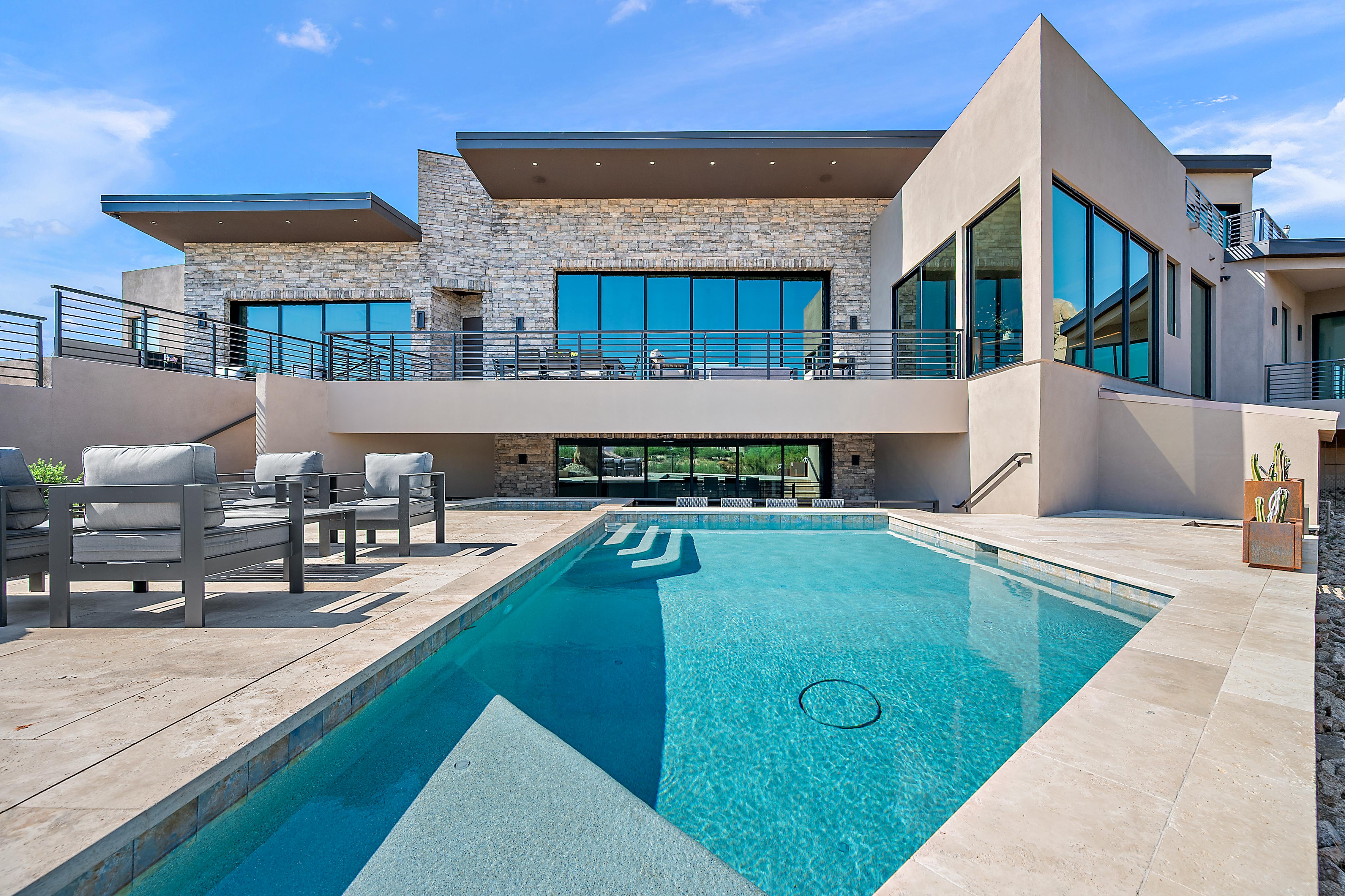 Luxury outdoor living renovation with covered stone column patio, custom pool, spa, outdoor dining, and Sonoran desert mountain views — N&M Home Services, Cave Creek AZ