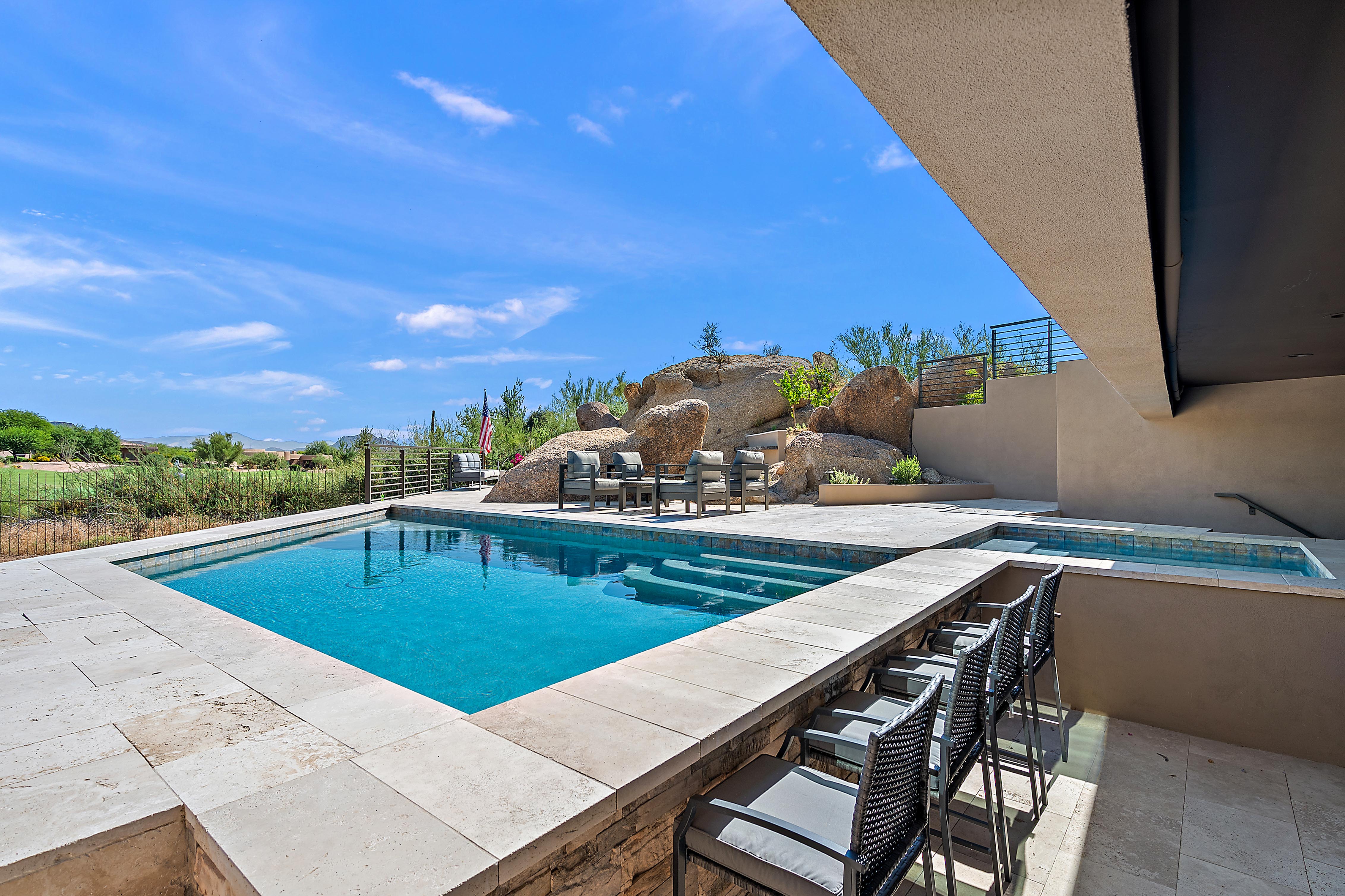Luxury backyard with custom freeform pool, stone retaining walls, artificial turf, spa, and built-in outdoor kitchen — N&M Home Services, North Scottsdale AZ