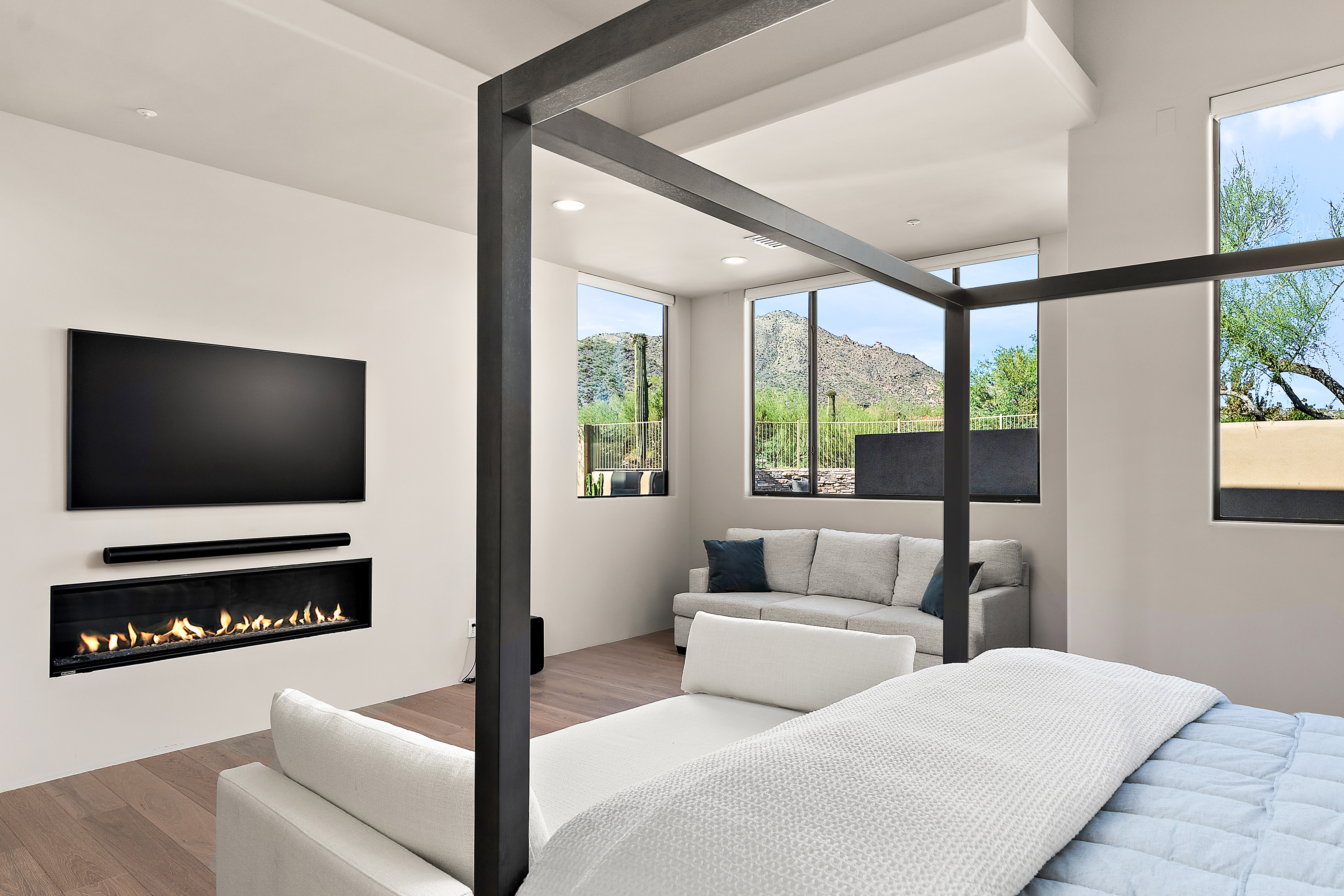 Luxury primary bedroom with linear fireplace, Sonoran desert mountain views, and spa-like finishes — N&M Home Services, North Scottsdale AZ