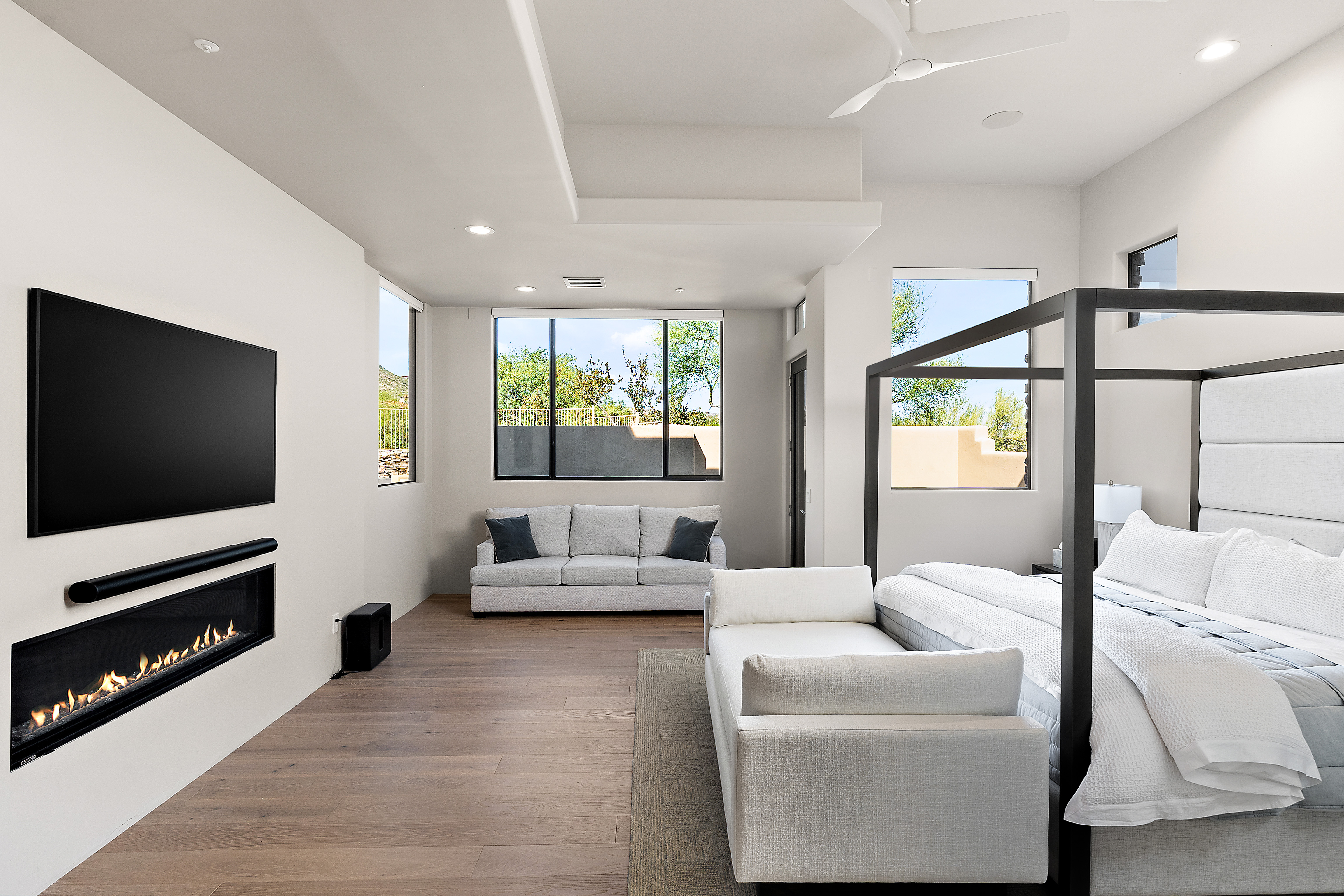 Luxury primary bedroom with linear fireplace, Sonoran desert mountain views, and spa-like finishes — N&M Home Services, North Scottsdale AZ