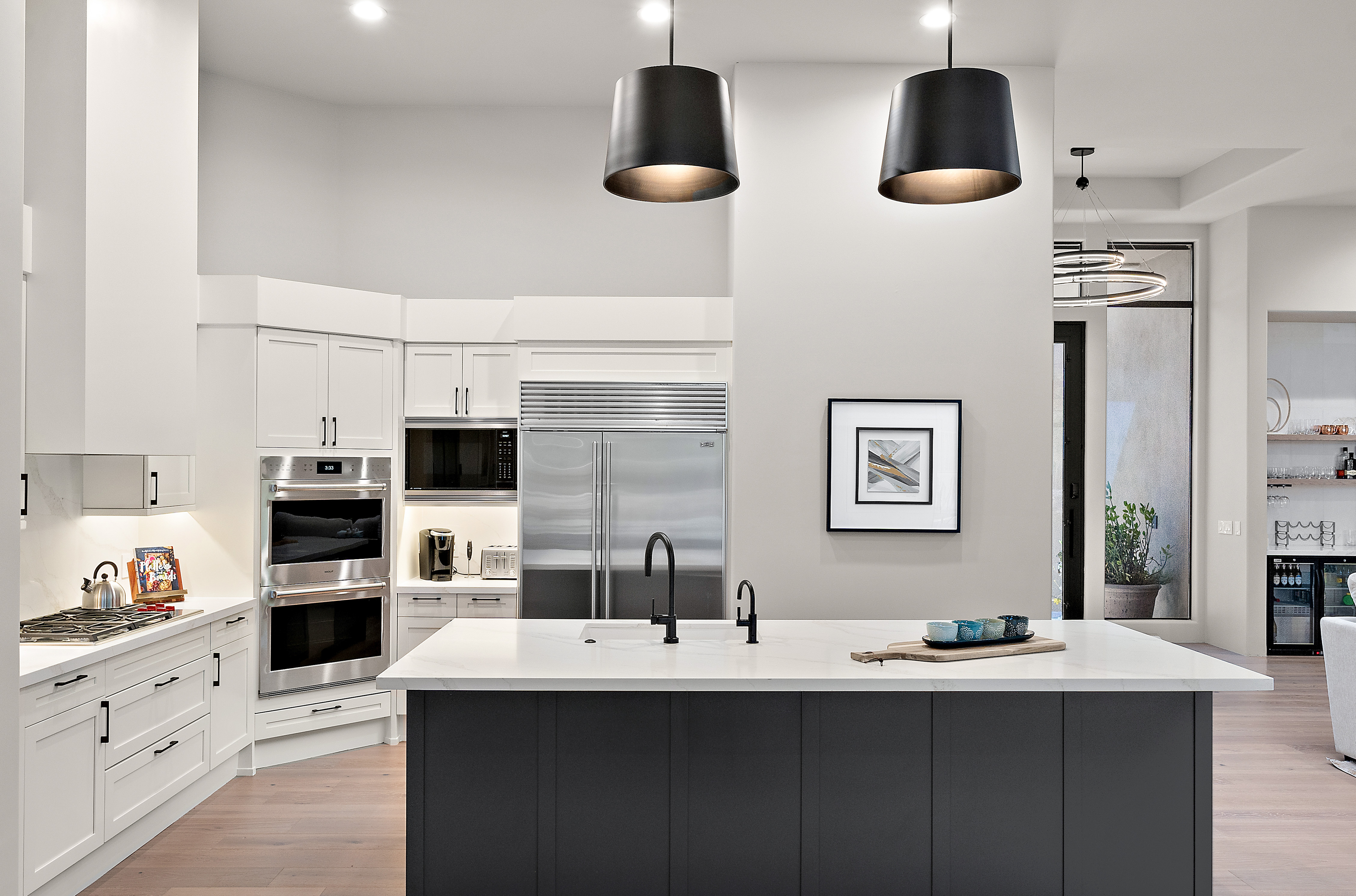 Luxury kitchen transformation with dark island, built-in double ovens, matte black fixtures, and open dining — N&M Home Services, Troon Scottsdale AZ