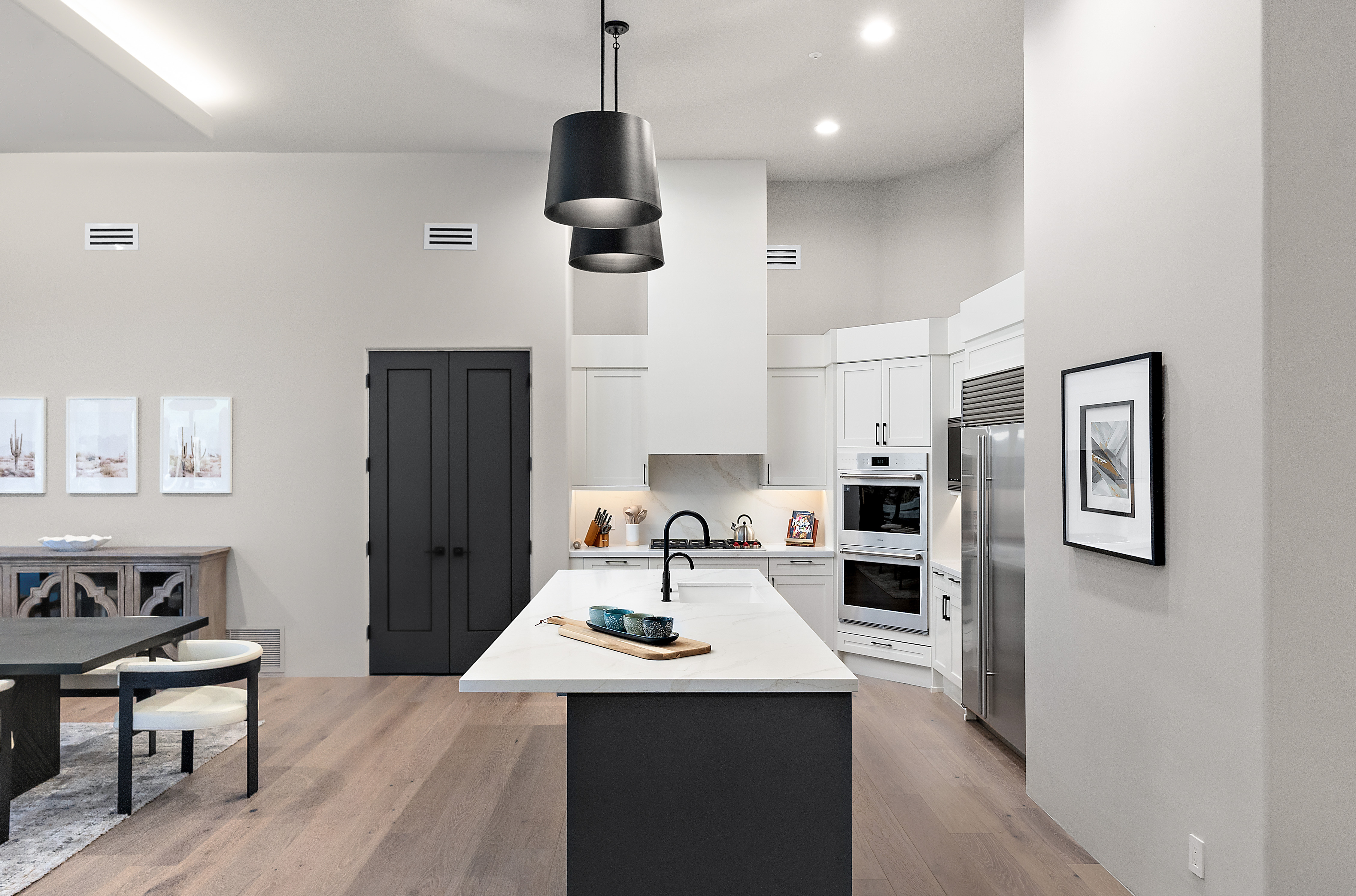 Luxury kitchen transformation with dark island, built-in double ovens, matte black fixtures, and open dining — N&M Home Services, Troon Scottsdale AZ