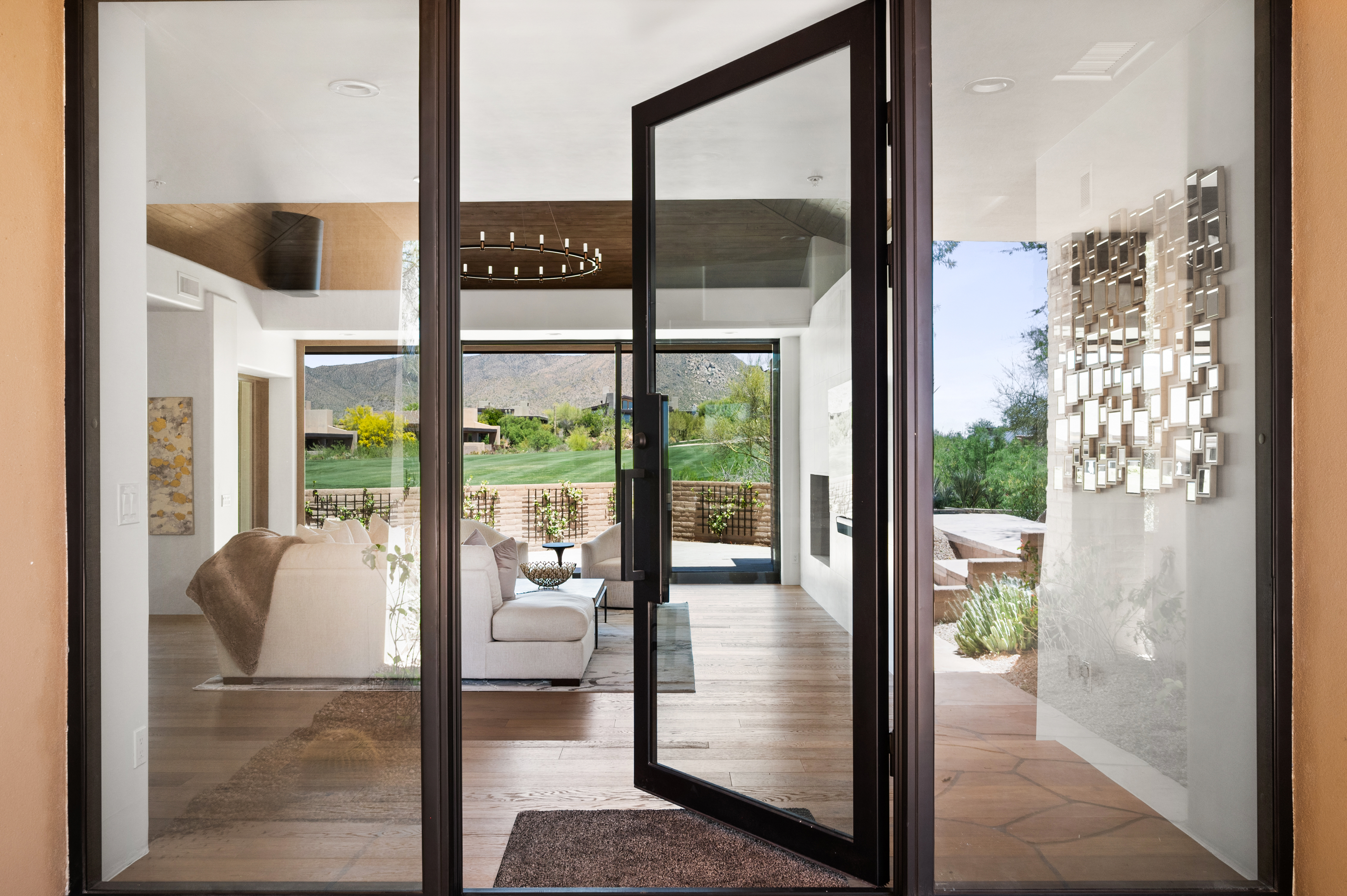Luxury living room renovation with Light concrete feature wall, linear gas fireplace, and floor-to-ceiling windows overlooking desert landscaping — N&M Home Services, DC Ranch Scottsdale AZ
