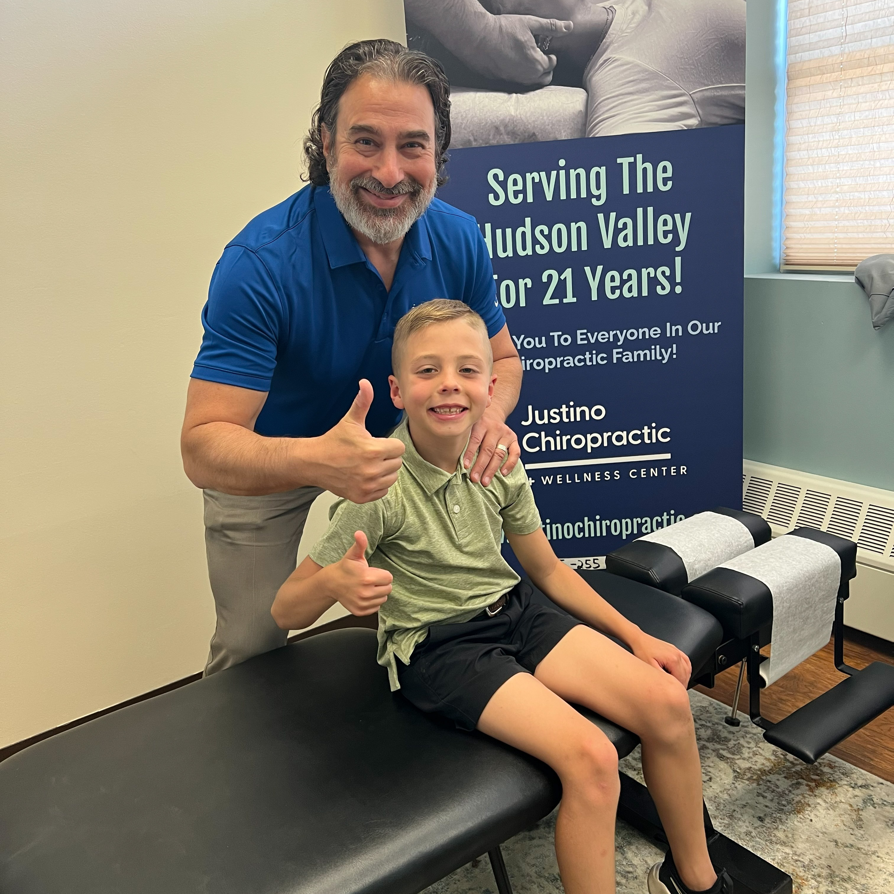 Dr. Vincent Justino with a young chiropractic patient at Justino Chiropractic Center