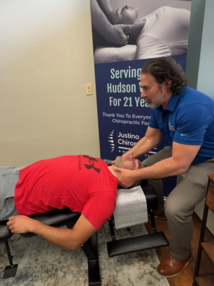 Dr. Vincent Justino performing a gentle chiropractic neck adjustment to improve mobility and reduce tension