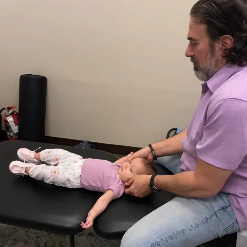 Chiropractor providing a gentle chiropractic adjustment for an infant using age-appropriate techniques.